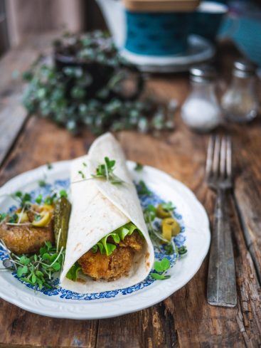 Wrap au poulet frit avec accompagnements sur assiette