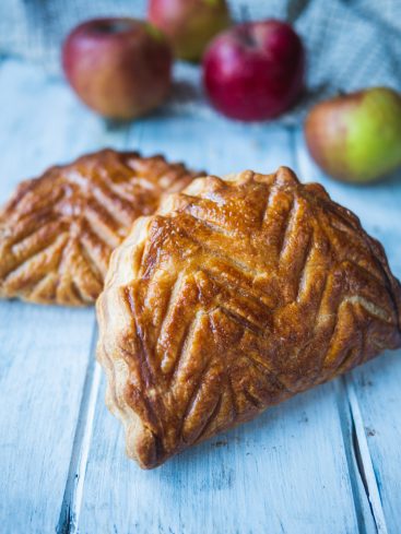 Chaussons aux pommes faits maison sur table en bois.