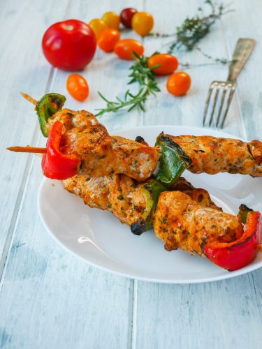 Brochettes de poulet et poivrons avec tomates.