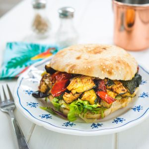 Sandwich végétarien grillé sur une assiette bleue et blanche.