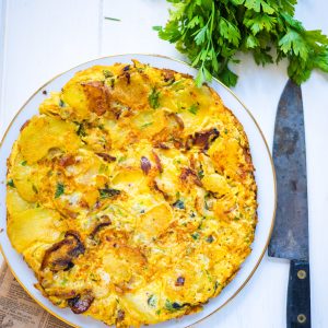 Tortilla de patatas avec persil et couteau