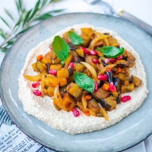Assiette de houmous garnie de légumes et grenade