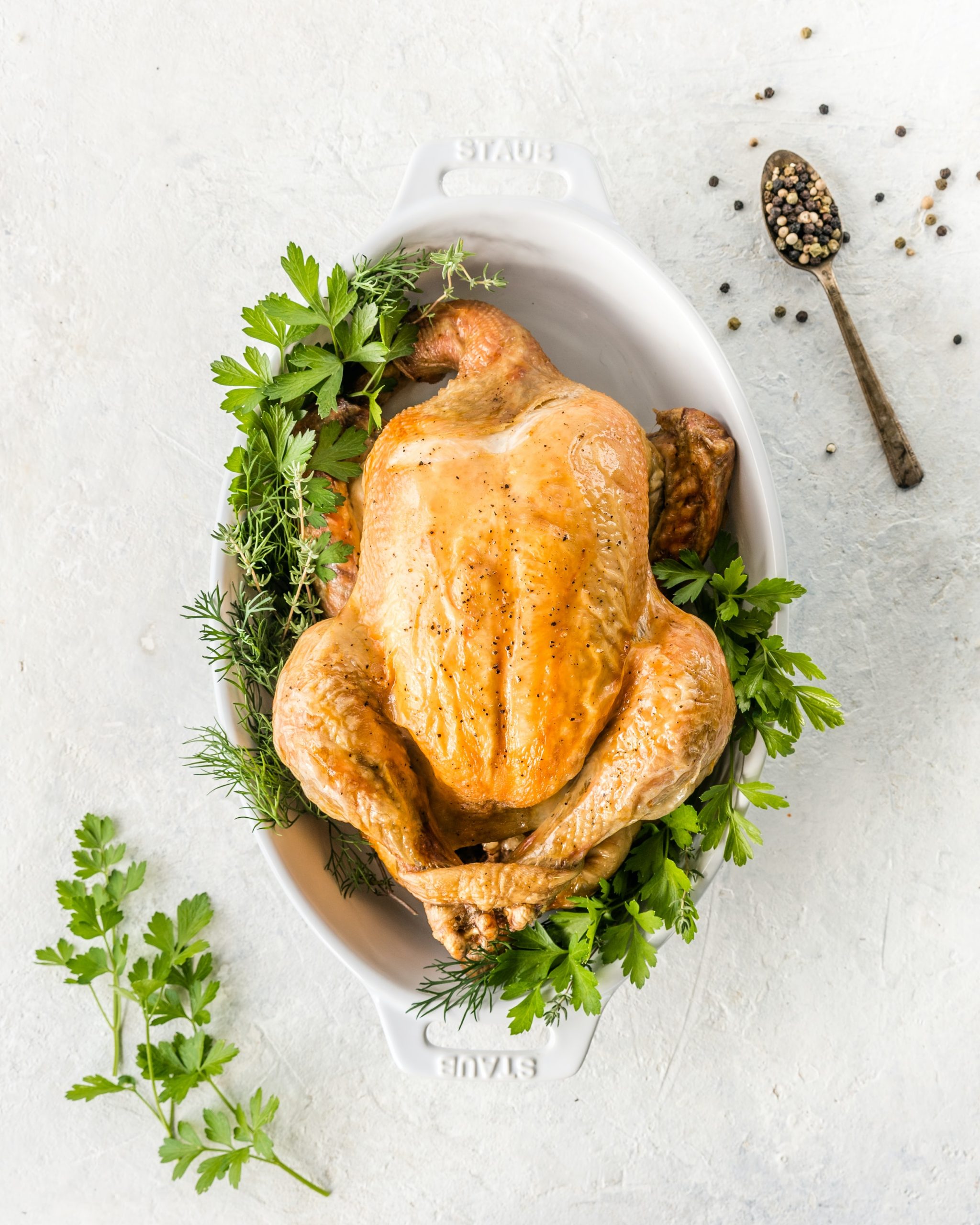 Poulet rôti Staub, herbes fraîches, cuillère de poivre.