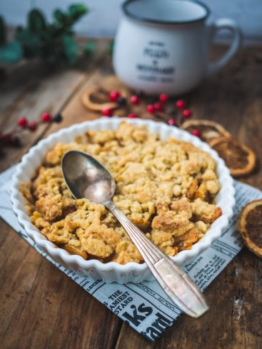 Crumble aux fruits, cuillère et tasse sur table en bois