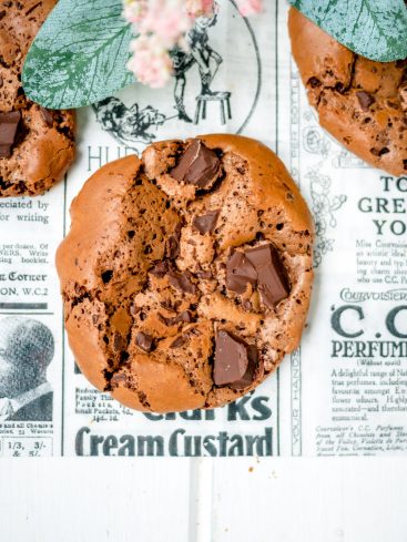 Cookie au chocolat sur journal ancien, fleurs décoratives.