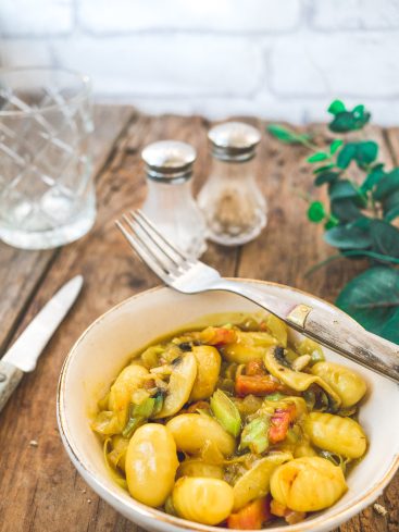 Plat de gnocchis aux légumes sur table en bois