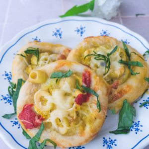 Mini pizzas aux olives et tomates sur assiette