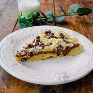 Tarte crumble chocolat, verre de lait, table en bois