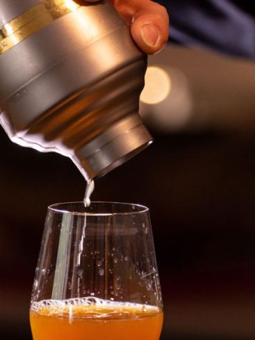 Cocktail versé dans un verre depuis un shaker