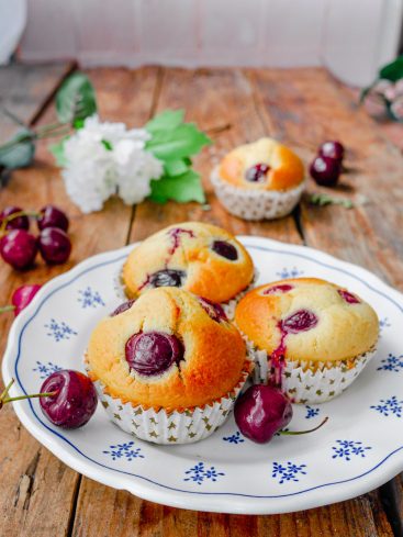 Muffins aux cerises sur assiette décorative, bois rustique.