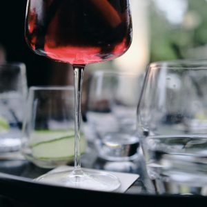 Cocktail rouge et verres d'eau sur plateau.