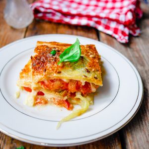 Lasagne aux légumes sur assiette blanche, fond rustique