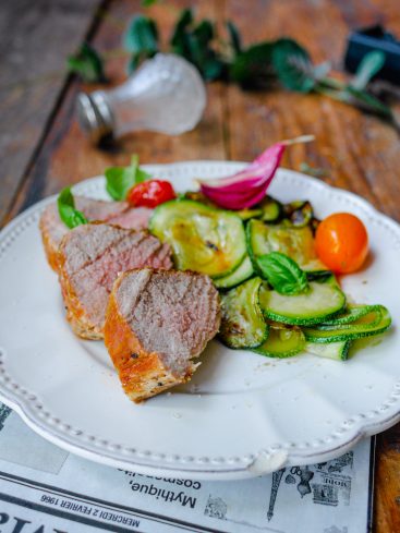 Filet mignon, courgettes grillées, tomates cerises sur assiette.