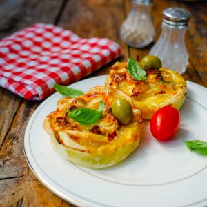 Mini quiches garnies sur assiette blanche, nappe vichy rouge.