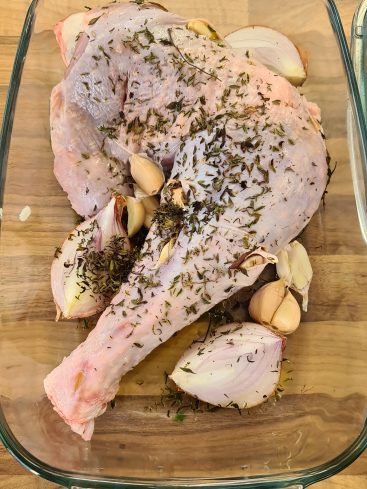 Cuisse de dinde crue avec herbes, ail et oignon.