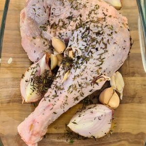 Cuisse de dinde crue avec herbes, ail et oignon.