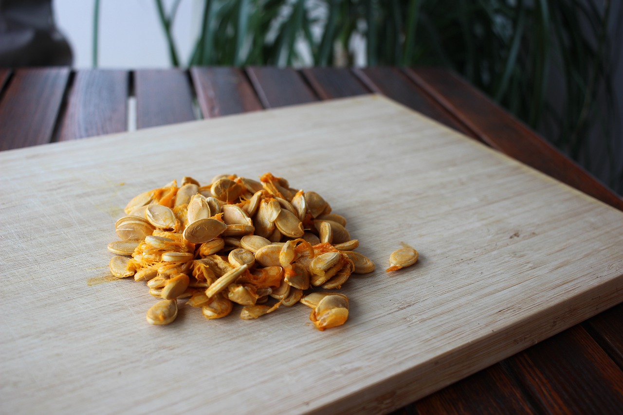 Graines de courge sur planche à découper en bois.