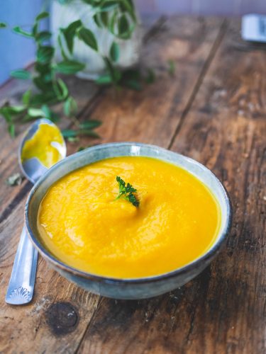 Bol de soupe de potiron sur table en bois