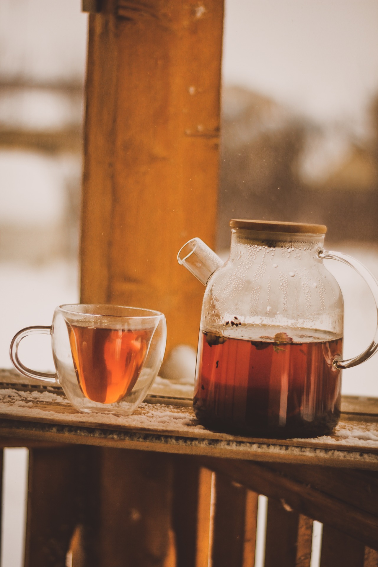 Théière et tasse de thé sur terrasse enneigée