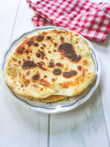 Pain plat cuit sur assiette avec une serviette.