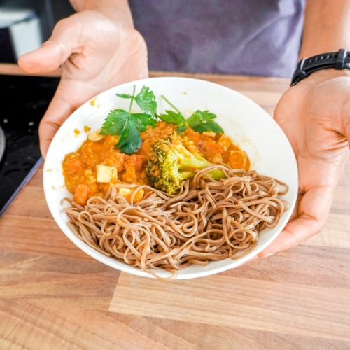 Assiette de nouilles soba avec brocolis et sauce tomates épicée