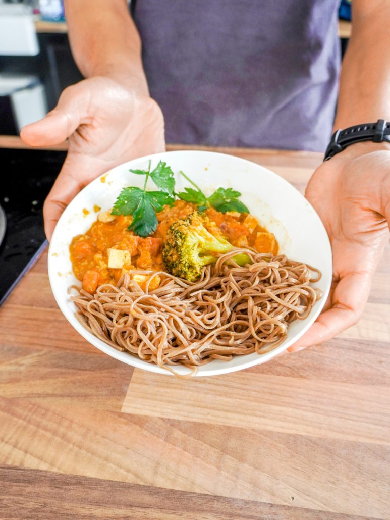 Assiette de nouilles soba avec brocolis et sauce tomates épicée