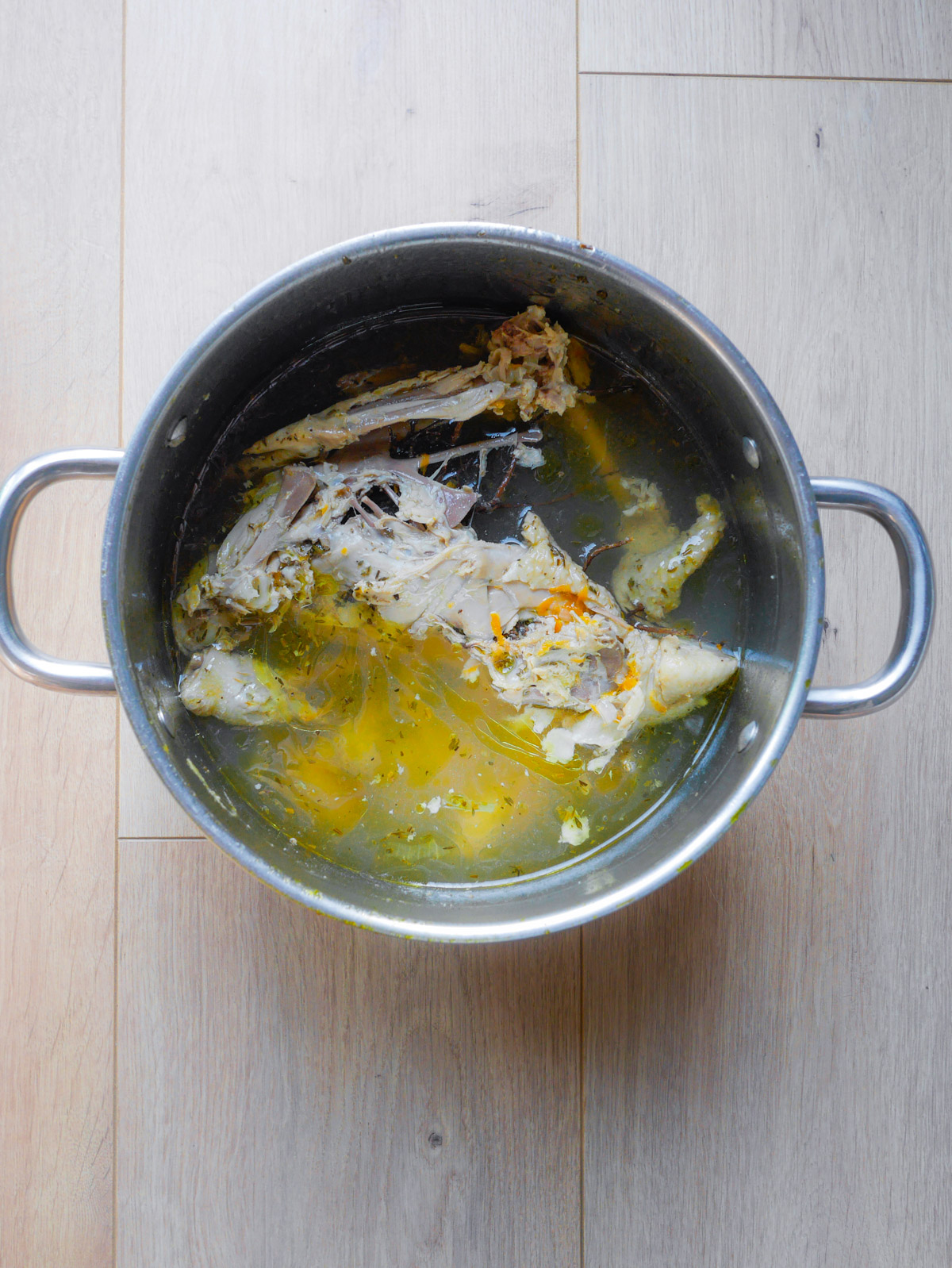 Carcasse de poulet dans une casserole de bouillon.