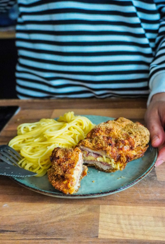 Cordon bleu maison, cuit au Airfryer, coupé en deux dans une assiette avec des spaghettis