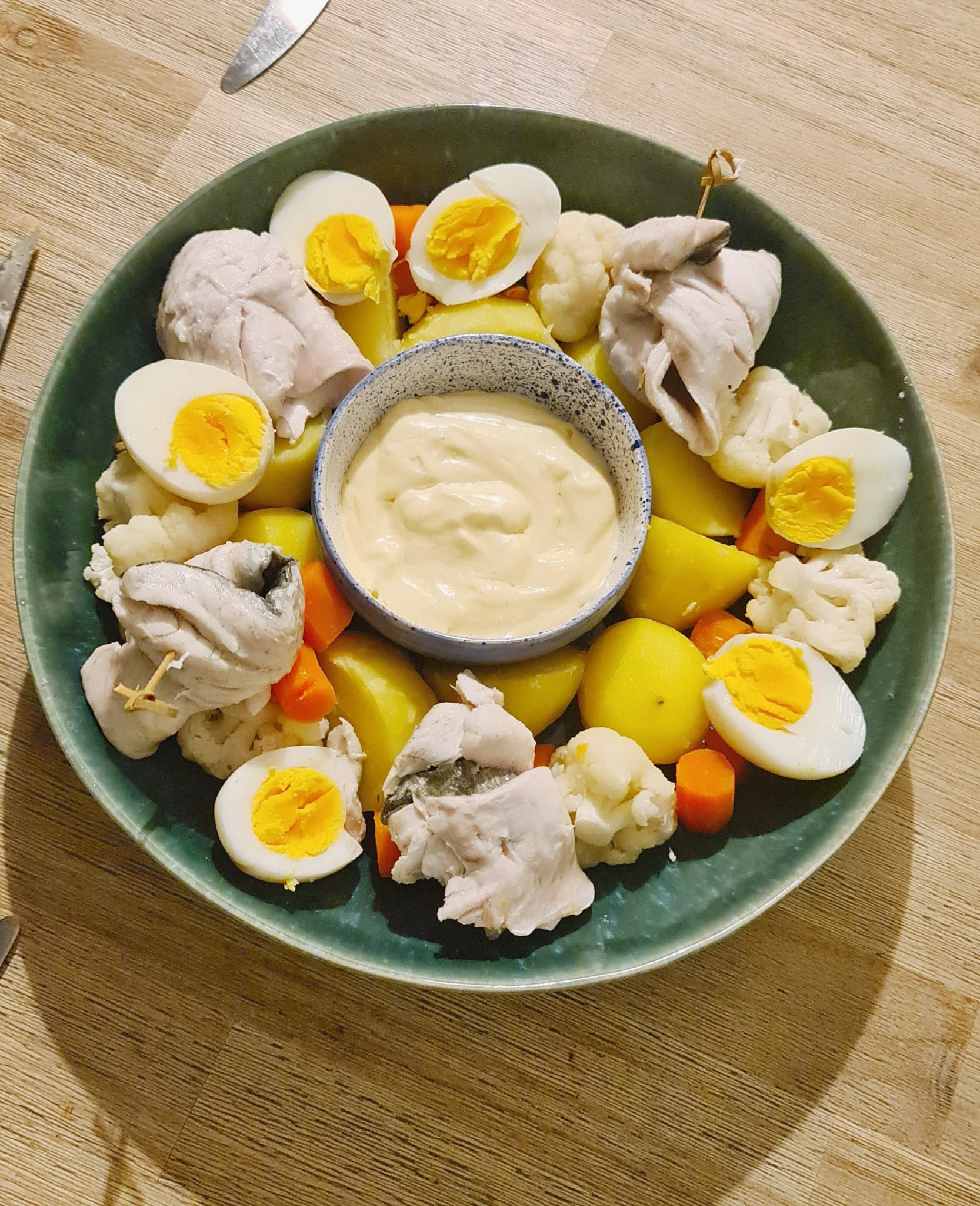 Assiette de poisson, œufs durs, légumes et sauce