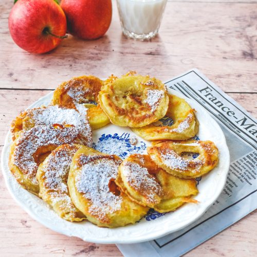 Beignets de pommes saupoudrés de sucre glace, pommes, lait.