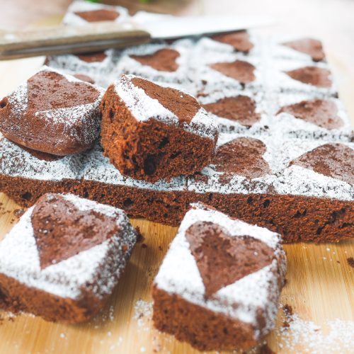 Brownies cœur saupoudrés de sucre glace sur bois.