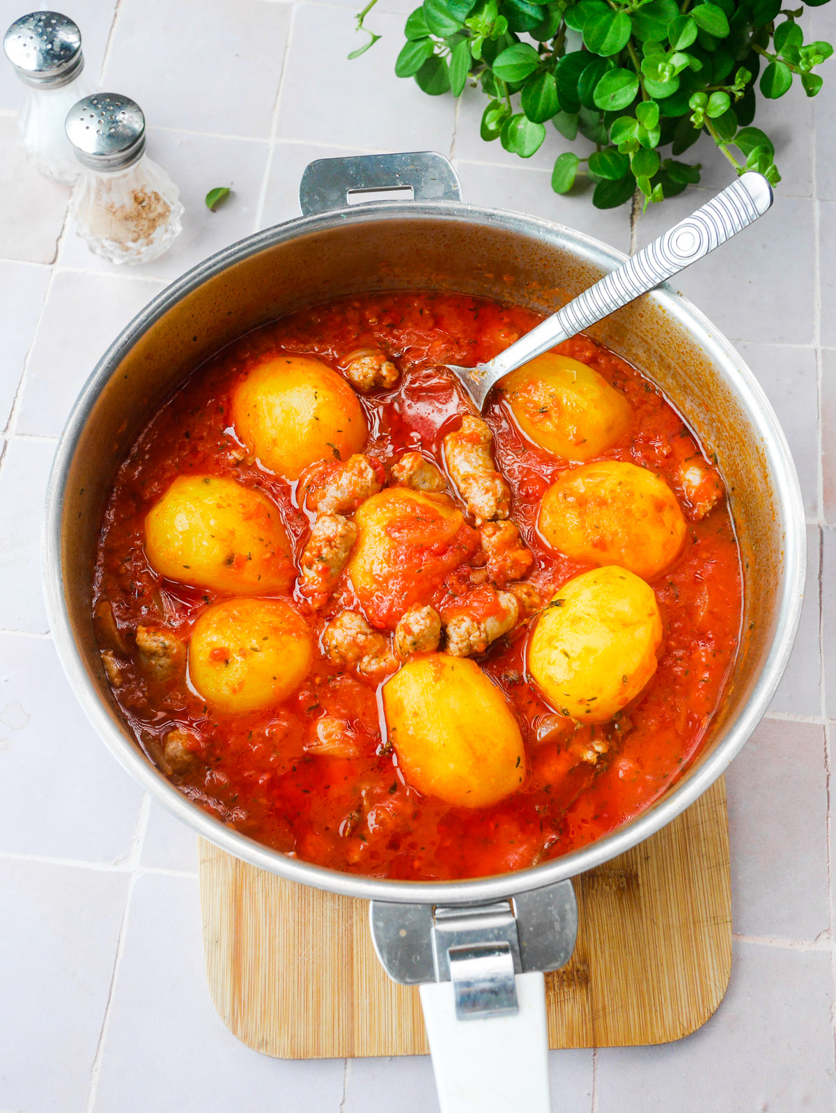 Ragout pommes de terre, sauce tomate et saucisses dans une sauteuse