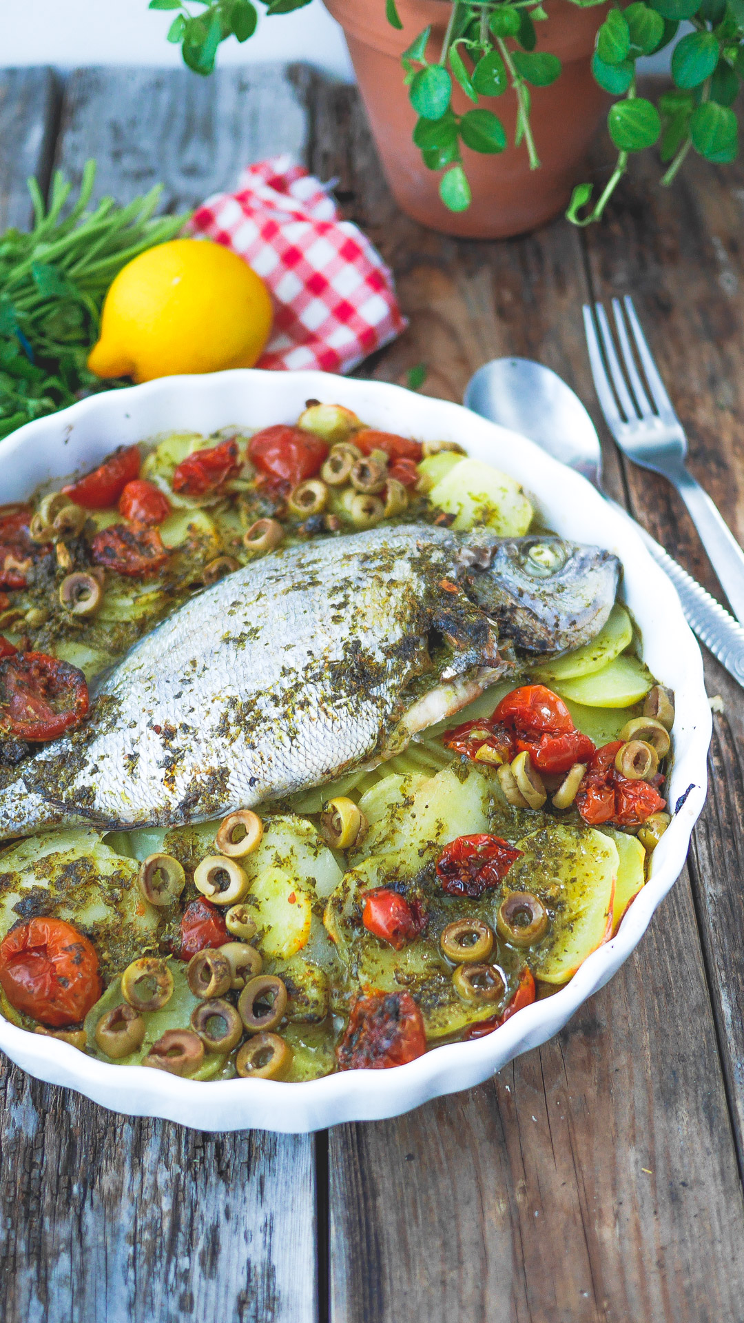 Plat de dorade au four avec légumes et herbes.