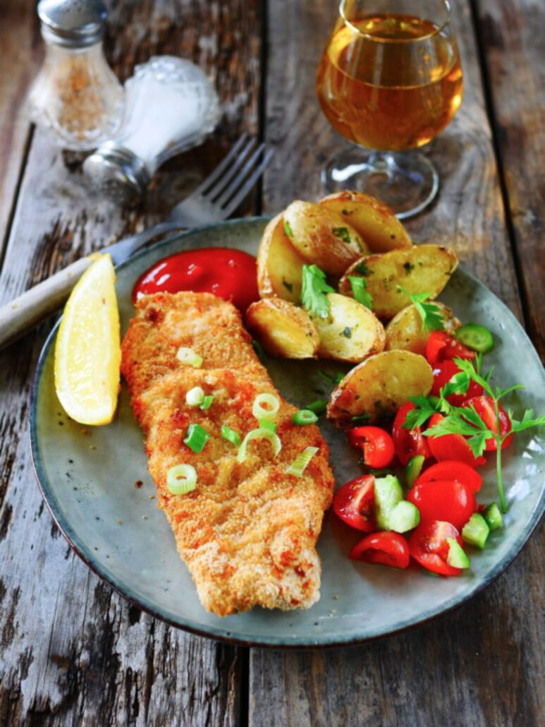 Escalope panée, pommes de terre et salade de tomates.