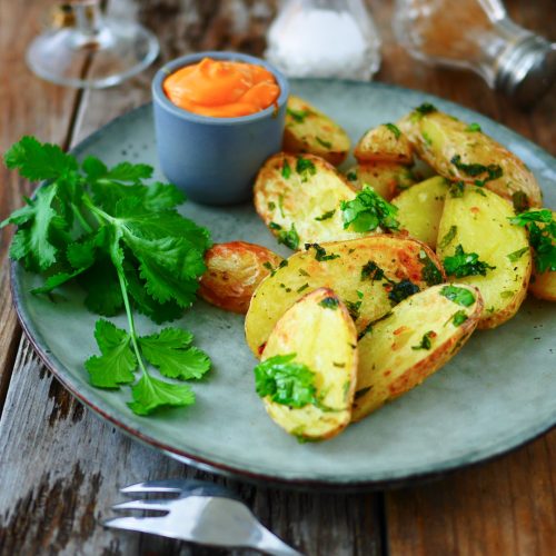 Assiette de pommes de terre, sauce, boisson et coriandre