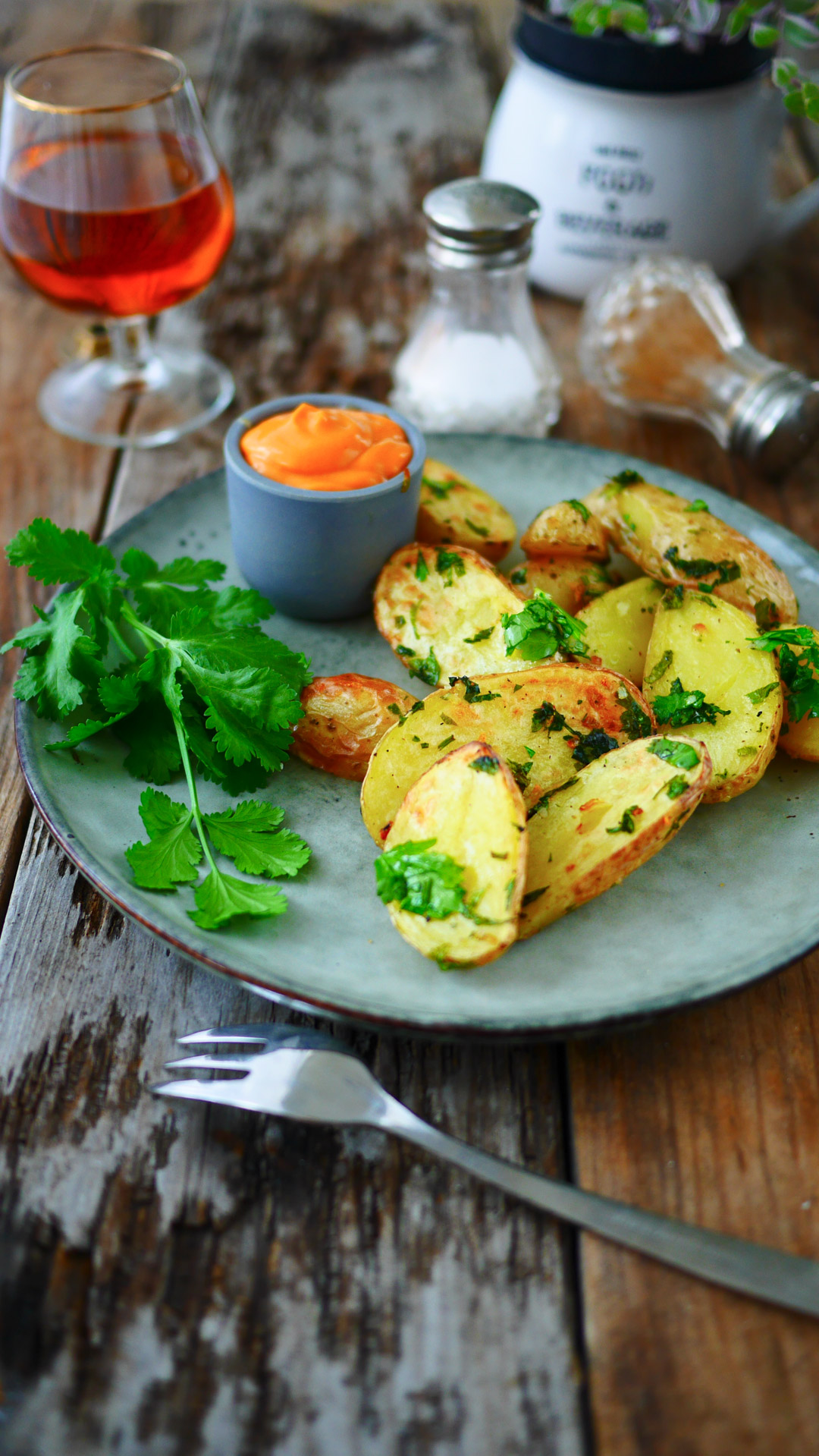 Assiette de pommes de terre, sauce, boisson et coriandre