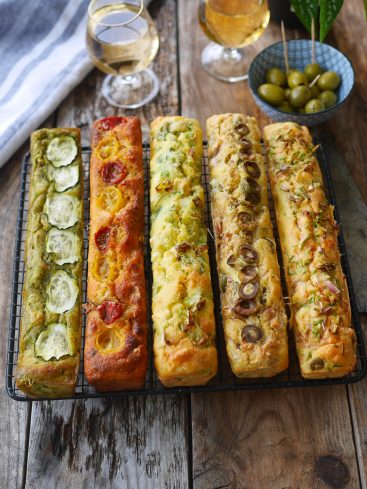 Cakes salés variés, olives, vin blanc sur table bois
