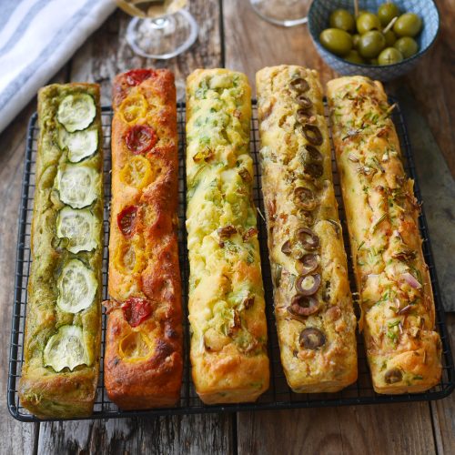 Cakes salés variés, olives, vin blanc sur table bois