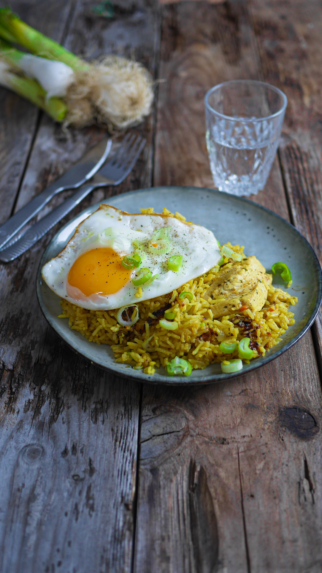 Plat de riz jaune avec œuf frit et poulet.