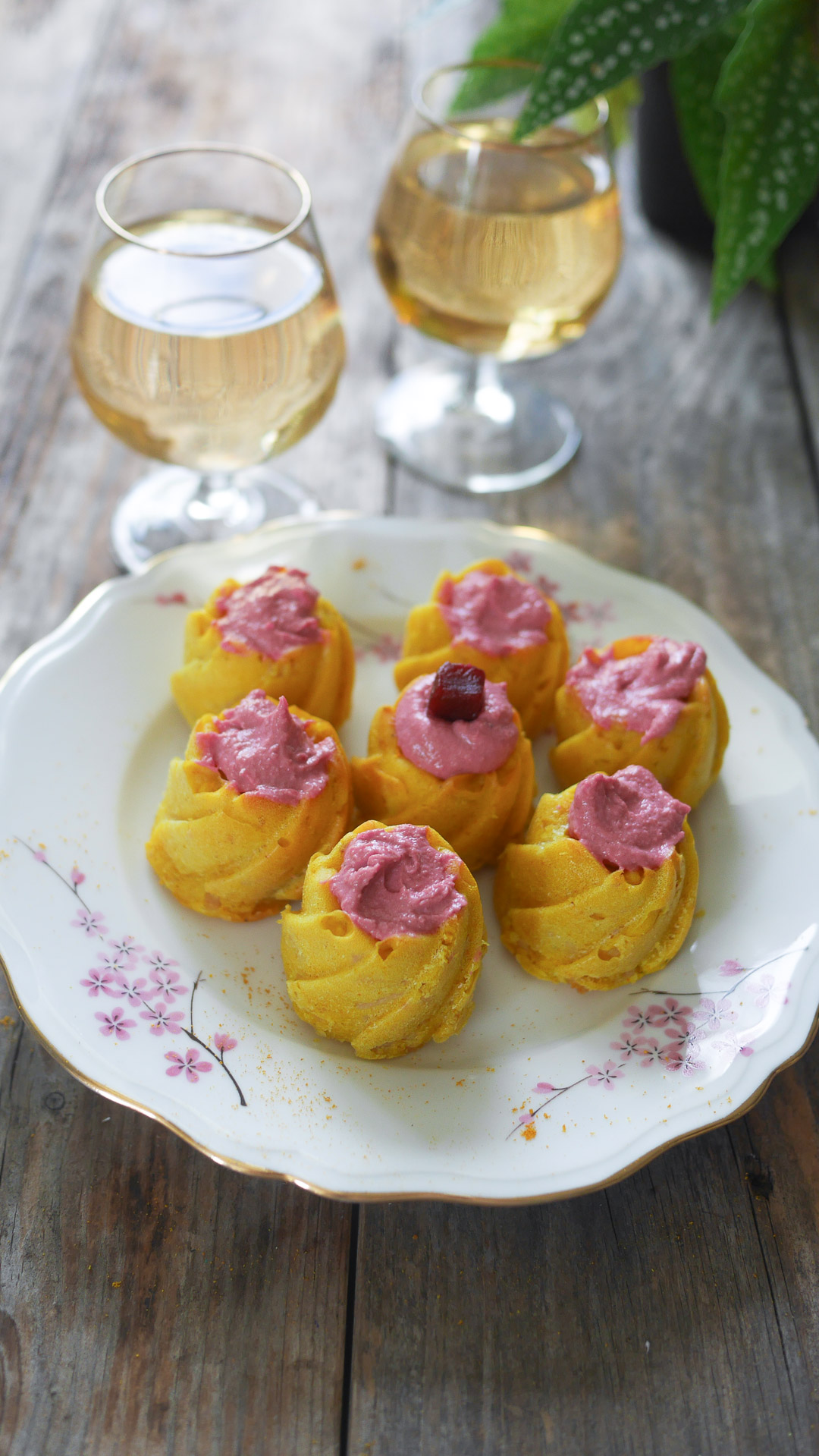 Plateau de gâteaux avec crème rose et vin blanc.