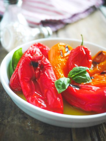 Poivrons rouges et jaunes grillés dans un plat blanc.