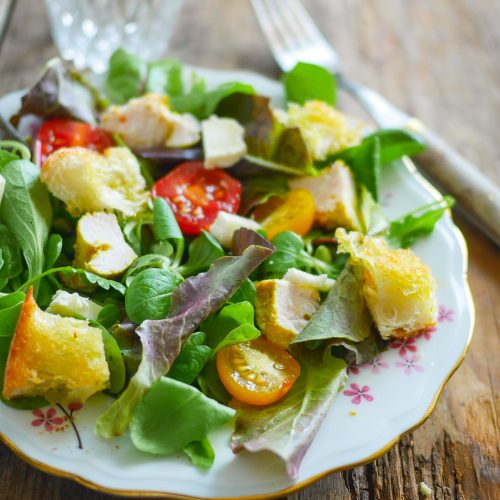 Salade de poulet, tomates et croûtons sur bois