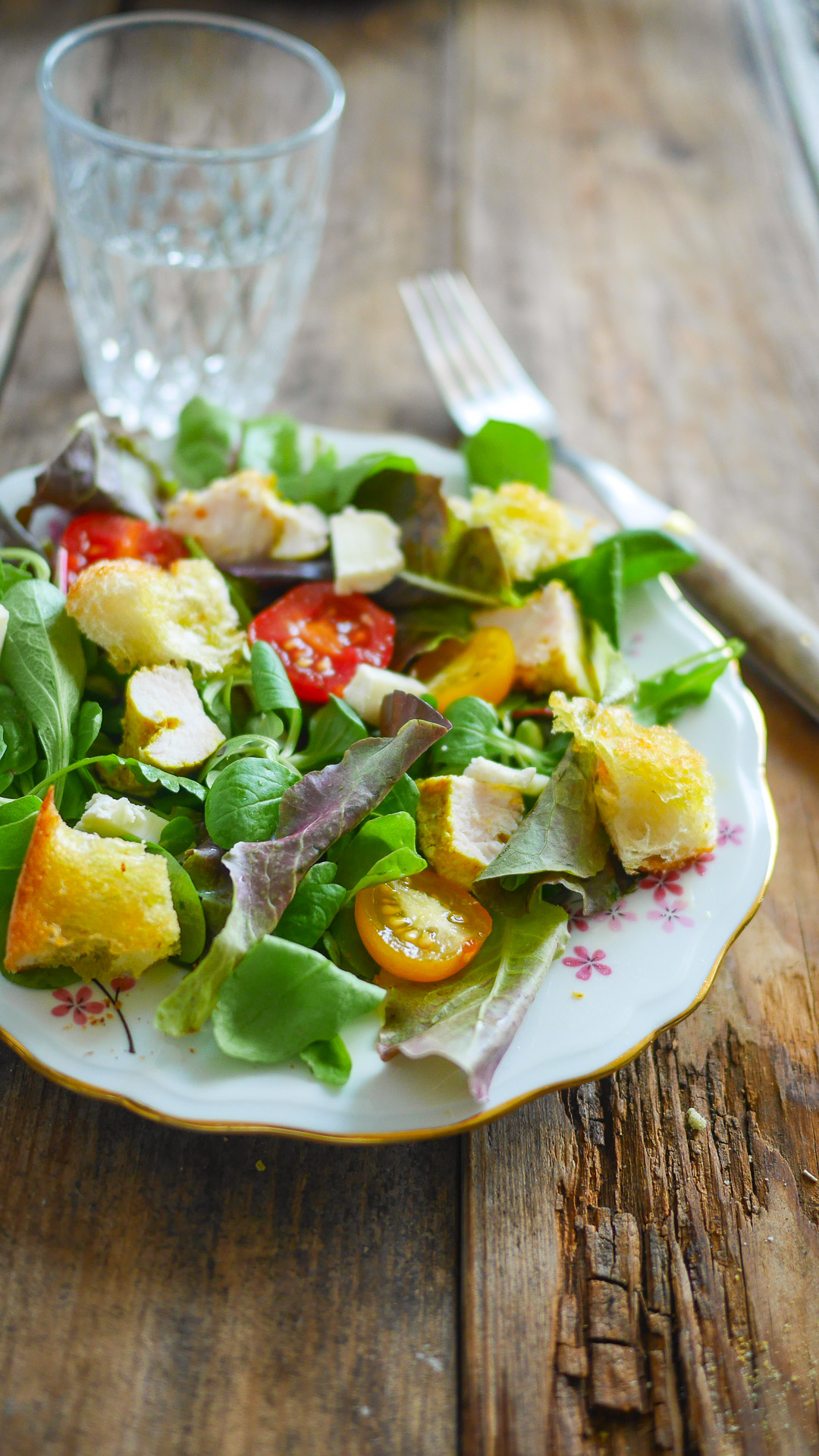 Salade de poulet, tomates et croûtons sur bois