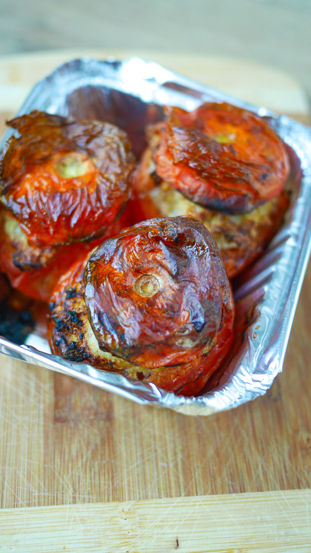 Tomates farcies cuites au four, dans un plat aluminium.
