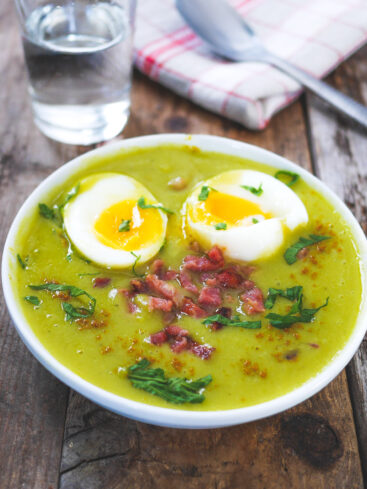 Assiette de soupe verte avec œufs et lardons.