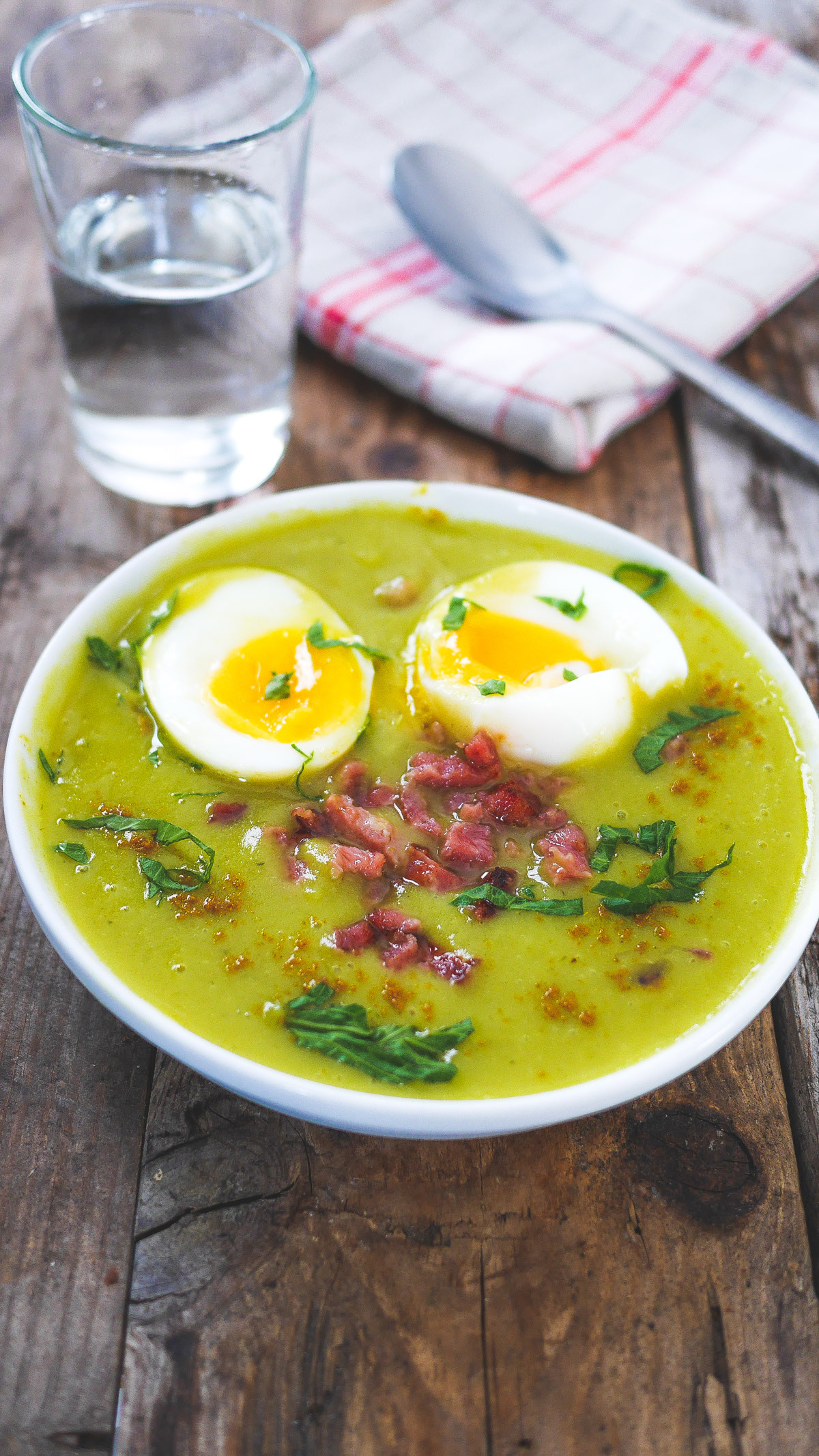 Assiette de soupe verte avec œufs et lardons.