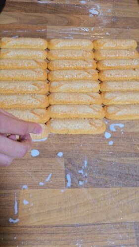Préparation de biscuits à la cuillère trempés dans du lait.