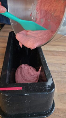 Pâte rose versée dans un moule à cake