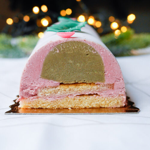 Bûche de Noël coupée, garniture pistache et framboise