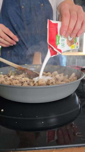 Lait de coco versé sur du poulet cuisiné